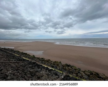 Sandy beach with cloud covered sky