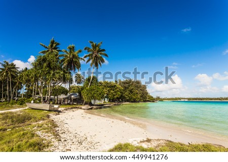 Sandy Beach with coconut trees and huts on the island of the Republic of Kiribati