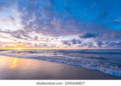 Sandy beach, colorful sky slightly cloudy at sunset, sea waves - Powered by Shutterstock