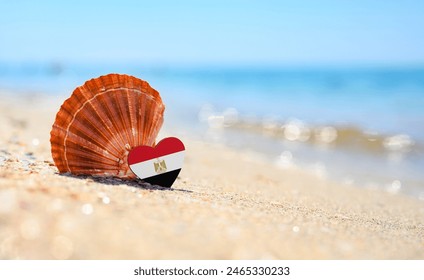 Sandy beach in Egypt. Egypt flag in the shape of a heart and a large shell. A wonderful seaside resort.
