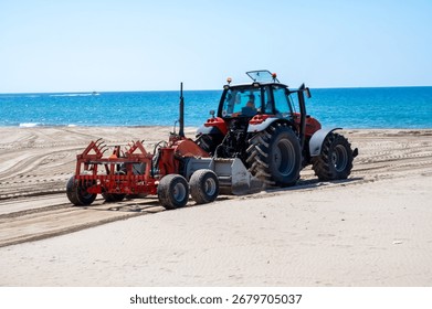 Sandy beach maintenance work before the season, tractor cleans seaweed and loosens sand, paid beaches in italy, private property, expensive beach holidays