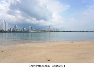 Sandy beach with the new highway over the bay and the skyscrapers of Panama city in background, Panama, Central America