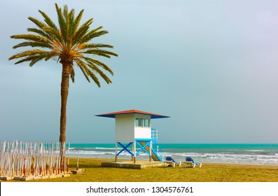 Sandy beach with palm tree and life guard tower in Larnaca, Cyprus - Powered by Shutterstock