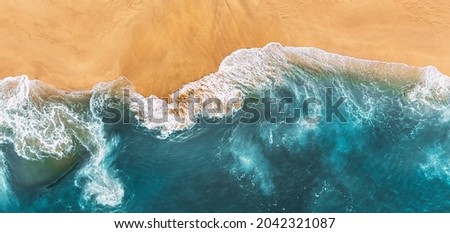 Sandy beach, panorama. Panoramic view of the sandy beach. The sea wave rolls on the shore. Sea coast view from the air. Aerial photography of the sea wave. The ocean and beach. Copy space