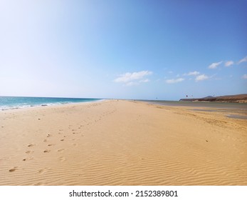 The Sandy Beach Of Playa De Sotavento With Footprints Under A Blue Cloudy Sky On A Sunny Day