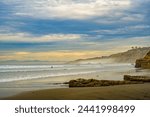 A SANDY BEACH WITH ROCK FACES WAVES AND A NICE SKY AT THE LA JOLLA SHORES IN LA JOLLA CALIFORNIA