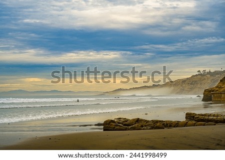 A SANDY BEACH WITH ROCK FACES WAVES AND A NICE SKY AT THE LA JOLLA SHORES IN LA JOLLA CALIFORNIA