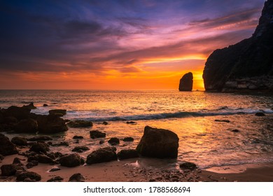 Sandy beach with rocky mountains and clear water of Indian ocean at sunset. Bali, Indonesia - Powered by Shutterstock