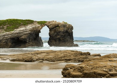 Sandy Beach with a Striking Natural Stone Bridge - Powered by Shutterstock