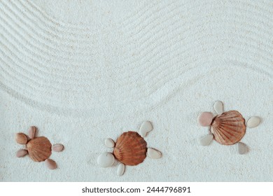 Sandy beach texture. Turtles made from shells and pebbles. Natural textured background. Top view, flat lay. Harmony, meditation,  concept.
