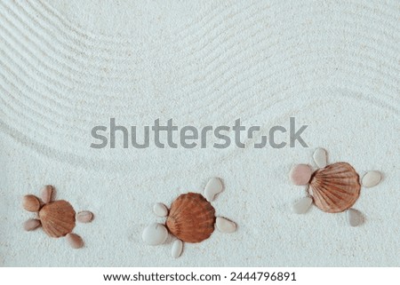 Sandy beach texture. Turtles made from shells and pebbles. Natural textured background. Top view, flat lay. Harmony, meditation,  concept.
