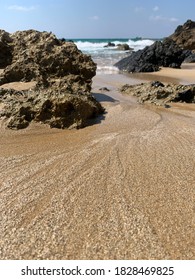 Sandy beach with the tide rolling back out.