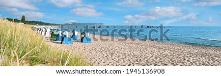 Sandy beach and traditional wooden beach chairs on island Rugen, Northern Germany, on the coast of Baltic Sea. Panorama image