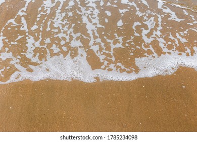 Sandy beach with waves. Empty sea and beach background with copy space