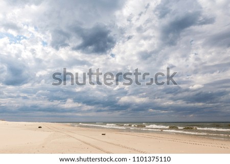Sandy beaches by the Baltic sea in Poland with dramatic sky in the background.