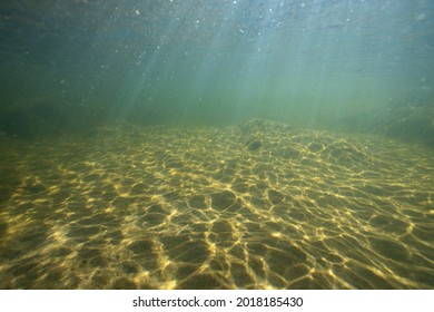 Sandy Bottom With Sunlight Reflections And Sun Beams. Underwater Landscapes Of The Baltic Sea.
