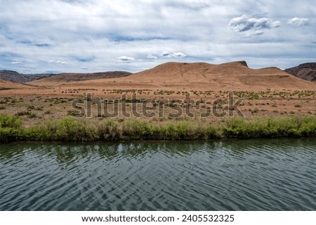 Sandy buttes rise behind the Owyhee River, southwestern Oregon, USA