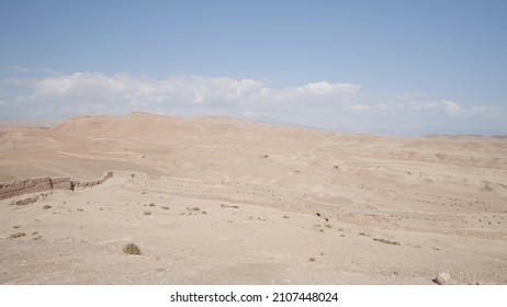 Sandy desert on blue cloudy background. Action. Natural landscape with the endless desert.