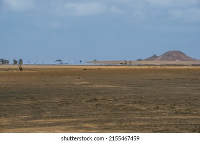 Sandy desert on the island of Sal in Cape Verde with a mirage and a mountain on the horizon.