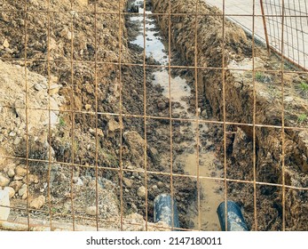 Sandy Ditch With Communications. The Moat Is Protected By A Metal Mesh In A New Microdistrict Of The City, Pipes Are Being Laid To Bring Communications To Residential Buildings.