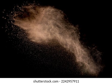 Explosión de arena aislada sobre fondo oscuro