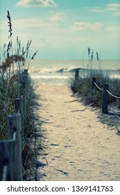 A sandy path leads to the beach