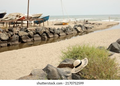 Sandy Shore With Parked Yachts And Sun Hat On The Ground