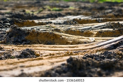 Sandy Soil With Traces Of Wheels Of Heavy Machinery. Industrial Landscape In The Style Of Macro Photography. The Illusion Of A Landscape In The Style Of Tilt-shift.