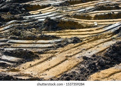 Sandy Soil With Traces Of Wheels Of Heavy Machinery. Industrial Landscape In The Style Of Macro Photography.