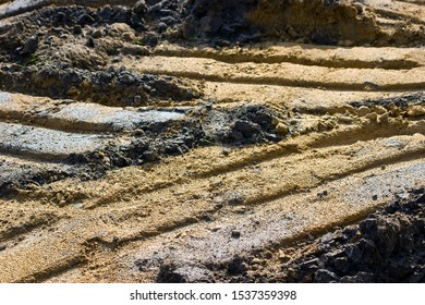 Sandy Soil With Traces Of Wheels Of Heavy Machinery. Industrial Landscape In The Style Of Macro Photography.