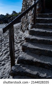 Sandy Stone Beach Stairs With Weathered Wood Handrails