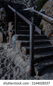 Sandy Stone Beach Stairs With Weathered Wood Handrails