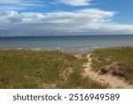 A sandy trail, leading over a grassy sand dune to Lake Michigan, in Kohler Andrae State Park, Sheboygan, Wisconsin, USA