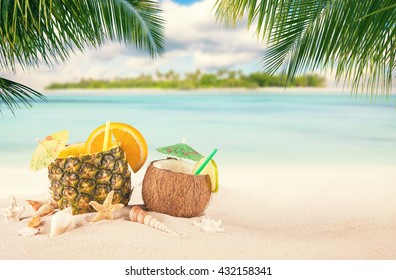 Sandy tropical beach with palm island and summer drinks