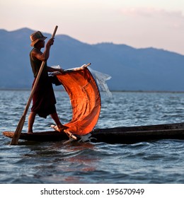 SANGHAR, MYANMAR - JANUARY 16: An unidentified fisherman of Intha tribe people in wooden boat during Htamanu festival on January 16, 2011 in Sanghar Village, Shan state, Myanmar