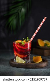 Sangria and ingredients. Refreshing sangria or punch with fruit in glasses . Sangria of red wine with ice. Traditional Spanish sangria . Drops from a squeezed orange.