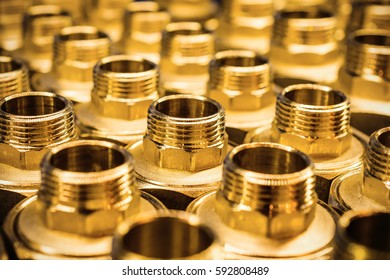 Sanitary Adapter Fittings golden brown. Orderly arranged in neat rows. Abstract industrial background.