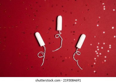 Sanitary Female Tampons With Red Glitter Stars On Red Background. Menstruation Cycle Period, Woman Hygiene.