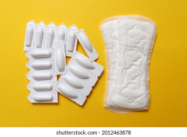 Sanitary Pads And Vaginal Suppositories On A Yellow Background, Top View, Flat Lay. The Concept Of Women's Sexual Health, Sexual Diseases, Candidiasis And Its Treatment, The Use Of Sanitary Napkin.