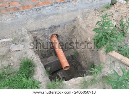 Sanitary Sewer Pipe in the House Foundation  Wall. Sewer pipe  in dirt hole during house sewer system construction.