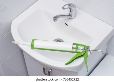 Sanitary Silicone Sealant Against The Background Of A Sink In The Bathroom