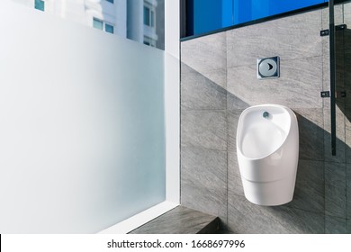 Sanitation White Ceramic Urinal In The Men's Bathroom With Hygienic Automatic Water-saving Electronic Flusher. Urine Sensor Urinal Inductive Toilet Flush. Office Or Public Bathroom. Real Photo.