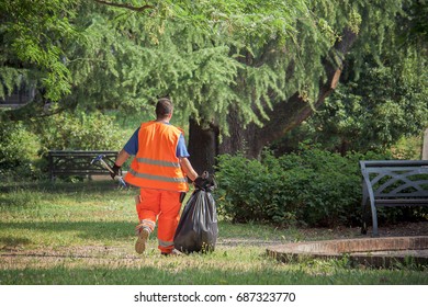 Sanitation Worker At The Park, Man With Hi Vis Vest Holding A Garbage Bag