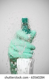 Sanitation Worker Spray Cleaning Agent On Glass Surface