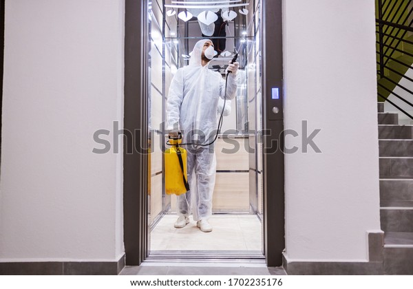 Sanitizing interior surfaces.
Cleaning and Disinfection inside buildings, the coronavirus
epidemic. Infection prevention and control of epidemic. Protective
suit and mask.