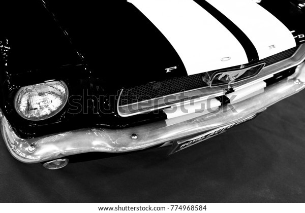 Sankt-Petersburg, Russia, July 21, 2017: Front view of\
Classic retro Ford Mustang GT.Car exterior details. Headlight of a\
retro car. Black and white. Photo Taken on Royal Auto Show  July,\
21 