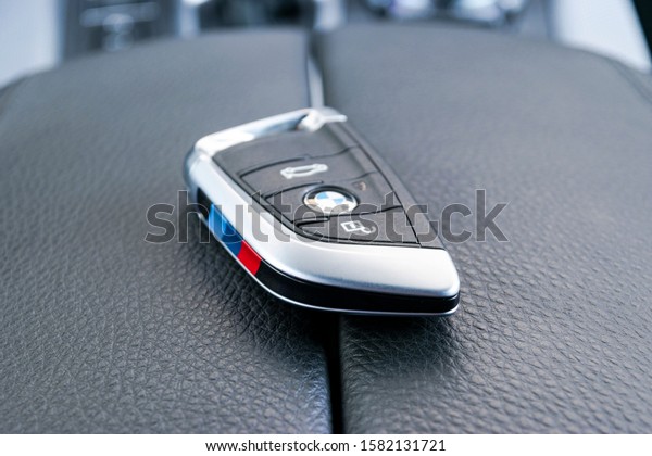 Sankt-Petersburg, Russia, March 05,\
2017:Close up of wireless keys of BMW X5M  in black leather car\
interior. Automatic gear stick shift background. Car interior\
details