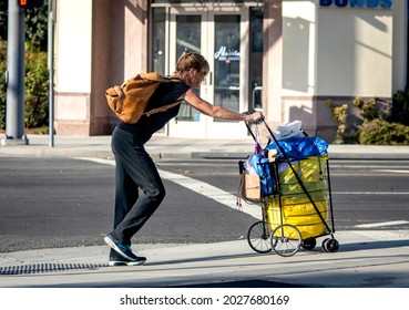 Santa Ana, CA USA 09-21-19 Homeless Woman Walking On City Street With Her Belongings 