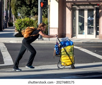 Santa Ana, CA USA 09-21-19 Homeless Woman Walking On City Street With Her Belongings 