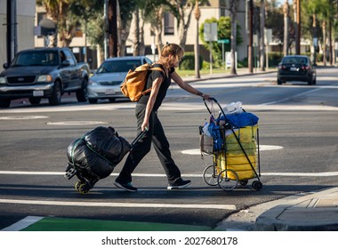 Santa Ana, CA USA 09-21-19 Homeless Woman Walking On City Street With Her Belongings 